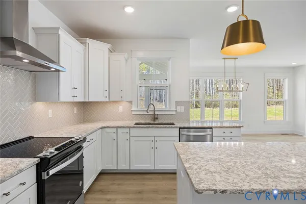 a kitchen with granite countertop a sink stainless steel appliances and cabinets