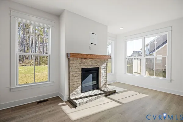 a view of a livingroom with wooden floor and a fireplace