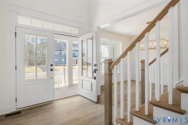 a view of an entryway with wooden floor and door