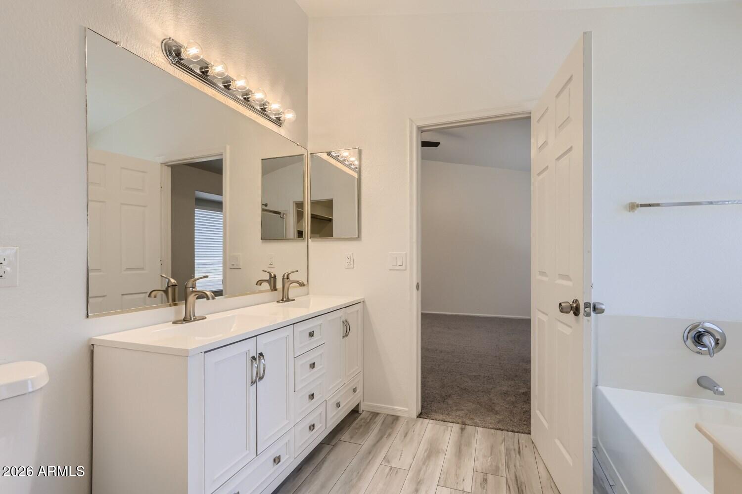 16033 West Diamond Street Goodyear, AZ 85338 - Photo 18 of 28 a bathroom with a double vanity sink and mirror with shower