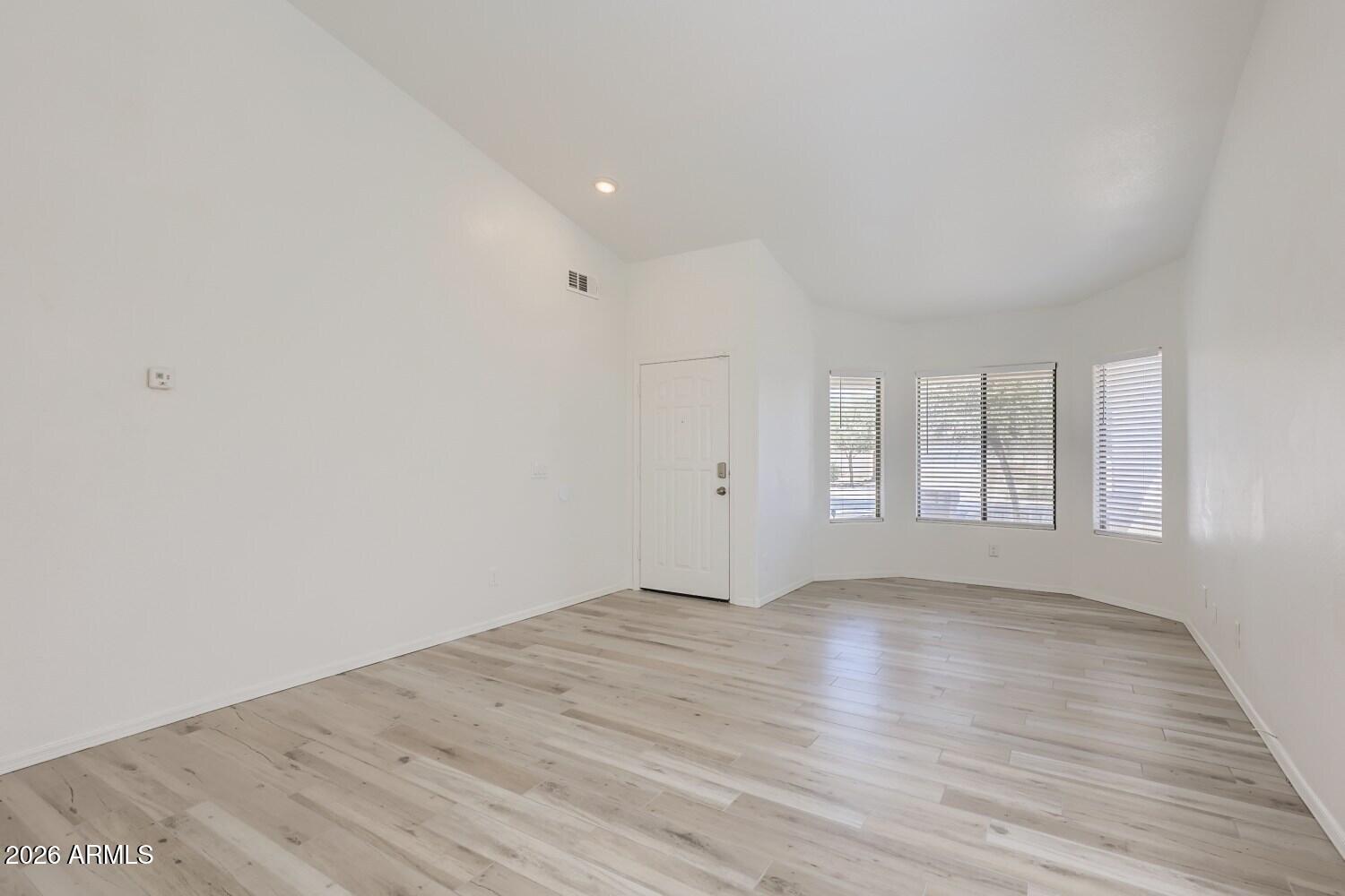 16033 West Diamond Street Goodyear, AZ 85338 - Photo 4 of 28 wooden floor in an empty room with a window