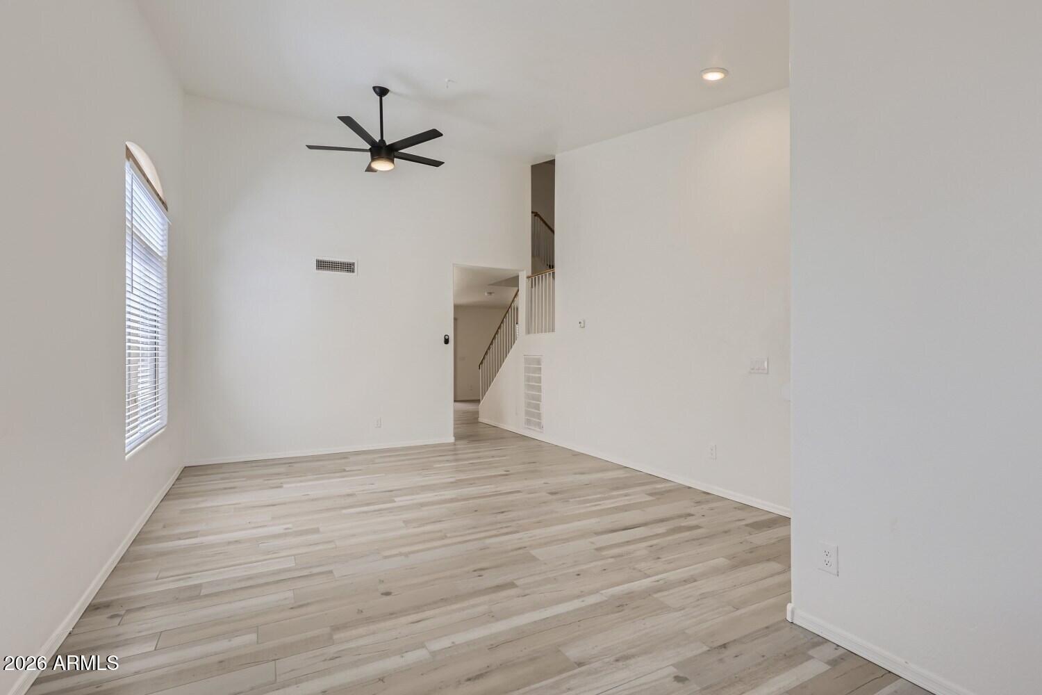 16033 West Diamond Street Goodyear, AZ 85338 - Photo 5 of 28 a view of empty room with wooden floor and fan