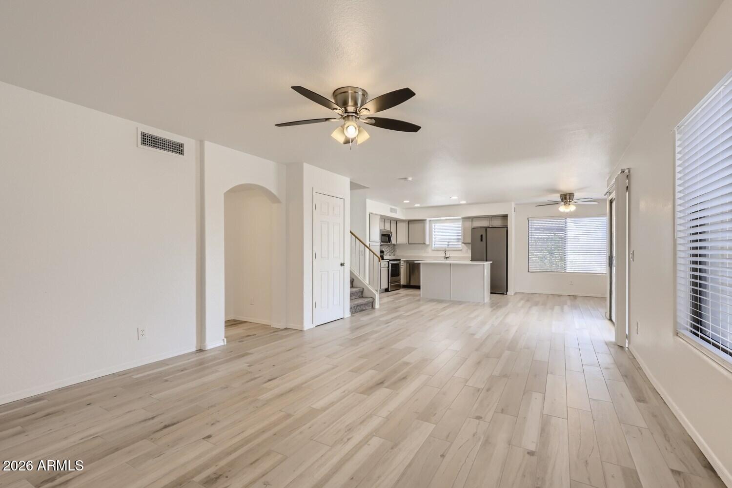16033 West Diamond Street Goodyear, AZ 85338 - Photo 9 of 28 a view of a kitchen with wooden floor and a ceiling fan