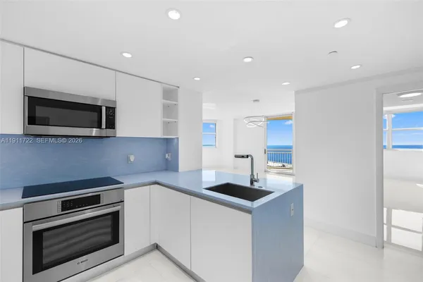 a kitchen with a refrigerator and white cabinets