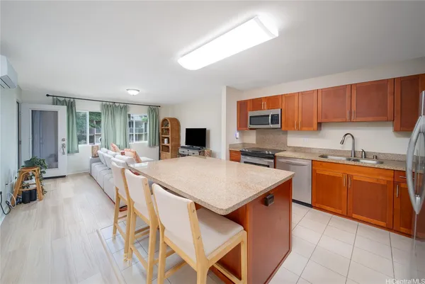 a kitchen with stainless steel appliances granite countertop a sink dishwasher and a refrigerator with wooden floor