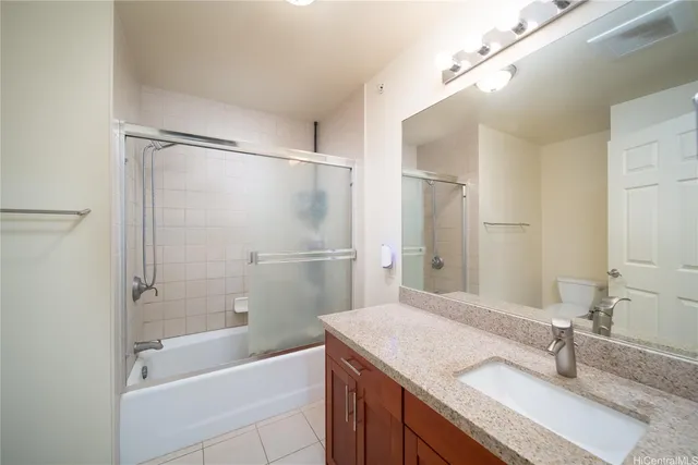 a bathroom with a granite countertop sink mirror toilet and bathtub