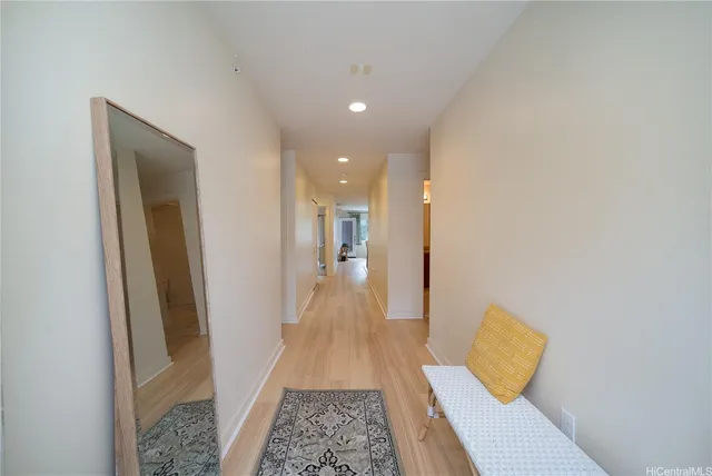 a view of a hallway with wooden floor and a couch
