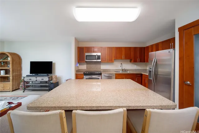 a kitchen with kitchen island a counter top space a sink stainless steel appliances and a window