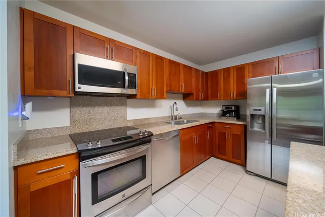 a kitchen with granite countertop a refrigerator stove top oven and sink
