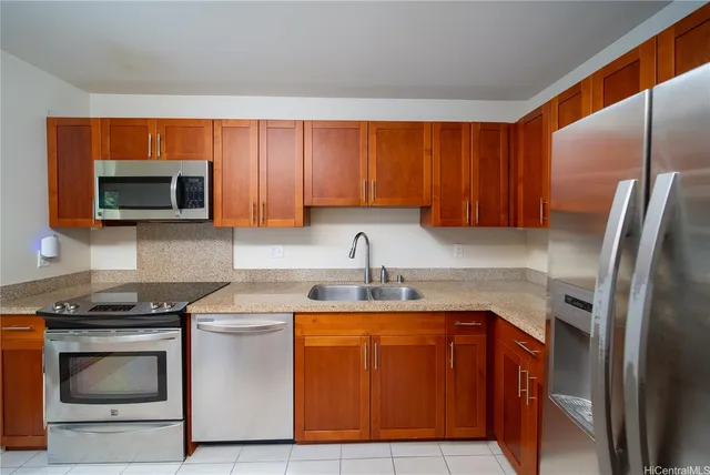 a kitchen with stainless steel appliances granite countertop a stove a sink and a microwave