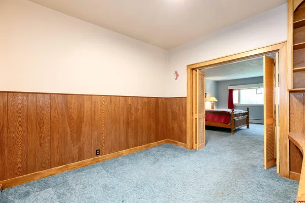 a bedroom with a bed and a flat tv screen on dresser