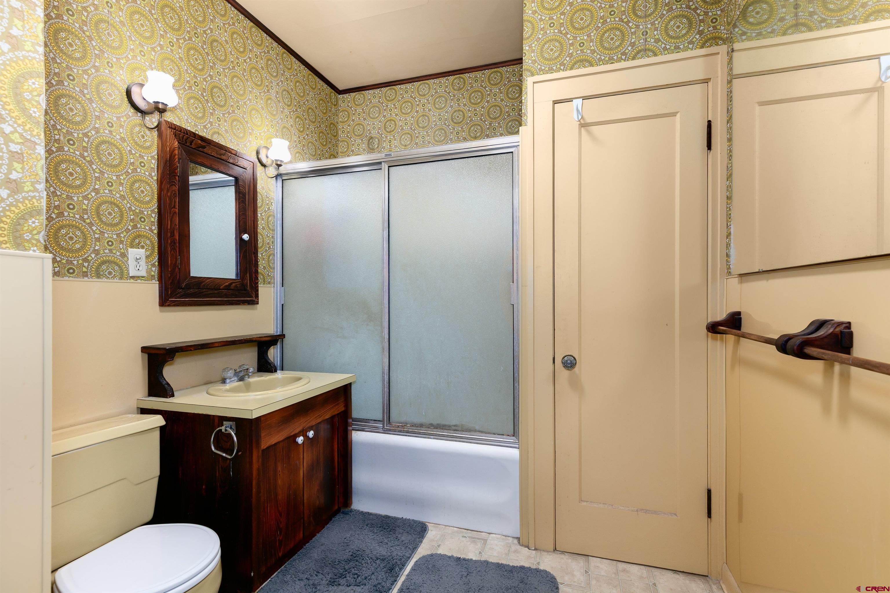 705 Oak Street Del Norte, CO 81132 - Photo 22 of 44 a bathroom with a granite countertop sink toilet and shower