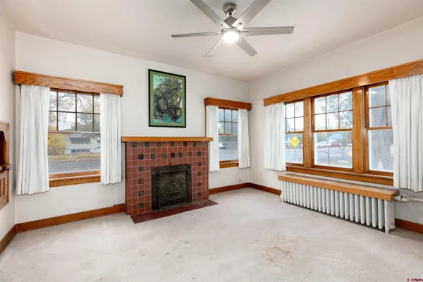 a view of an empty room with window and fire place