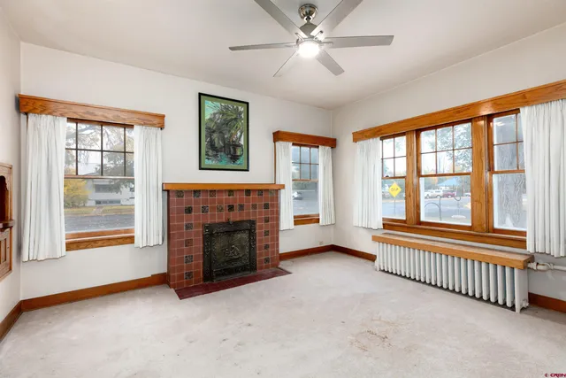 a view of an empty room with window and fire place