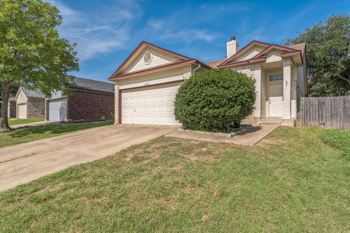 View of front of house featuring concrete driveway, an attached garage, and a chimney