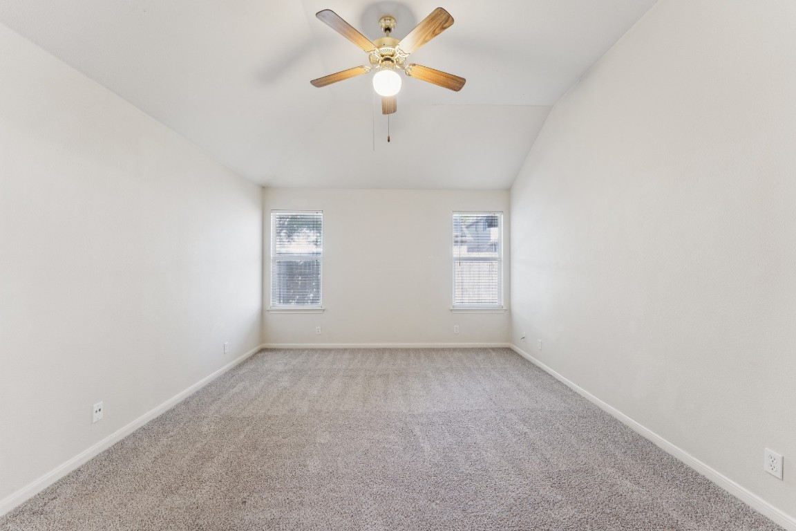 21308 Secretariat Ridge Lane Pflugerville, TX 78660 - Photo 10 of 18 Unfurnished room with lofted ceiling, carpet flooring, and ceiling fan
