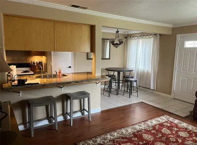 a kitchen with granite countertop a table chairs stove a sink and dishwasher