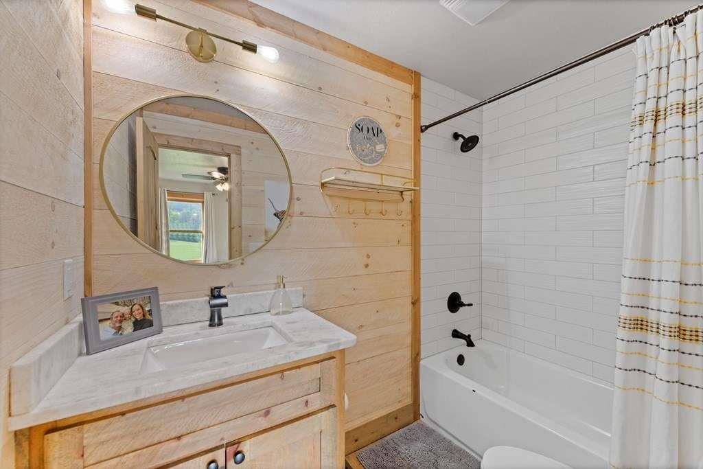 384 Maxwell Road Blue Ridge, GA 30513 - Photo 30 of 68 a bathroom with a granite countertop sink a mirror a vanity and bathtub