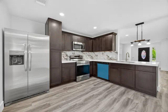 a kitchen with a refrigerator sink and cabinets