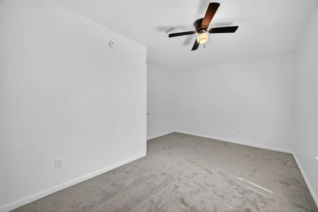 a view of empty room with ceiling fan