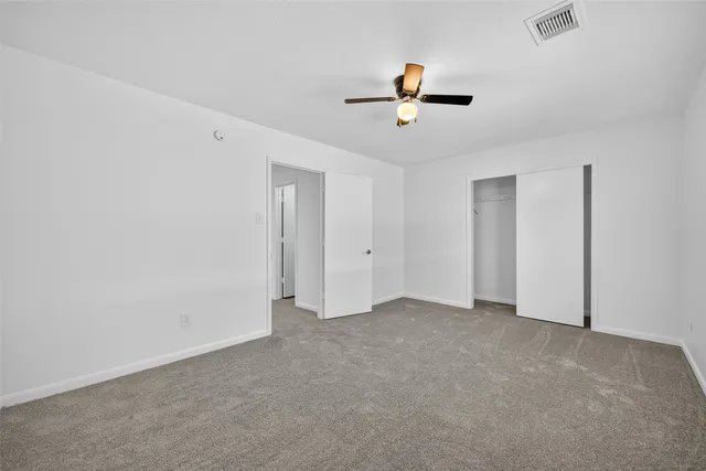 a view of an empty room with a ceiling fan