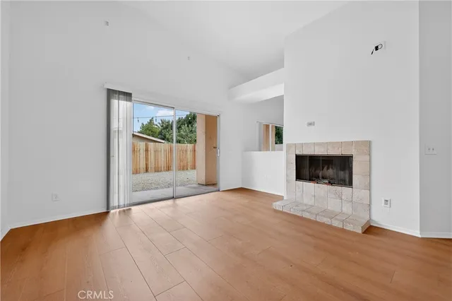 a view of an empty room with a fireplace and a window