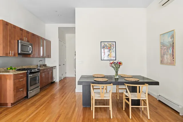a kitchen with stainless steel appliances granite countertop a lot of counter space and wooden floors