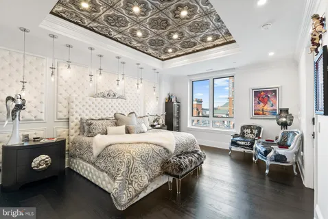 a bedroom with a bed and a painting on the wall