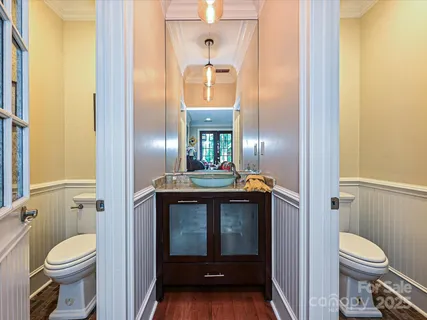 a bathroom with a granite countertop toilet a sink and a mirror