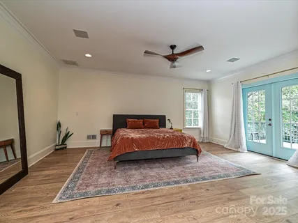 a spacious bedroom with a bed a dresser and a large window