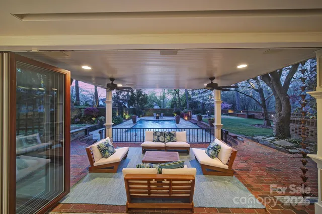 a view of a patio with couches table and chairs and potted plants