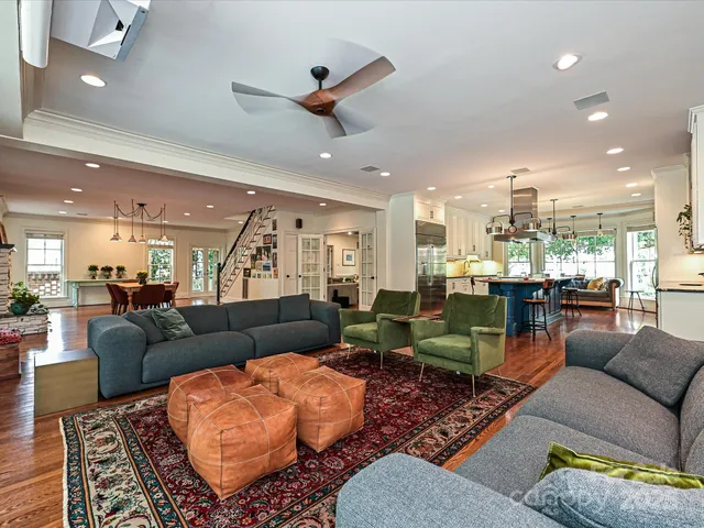 a living room with furniture kitchen view and a chandelier
