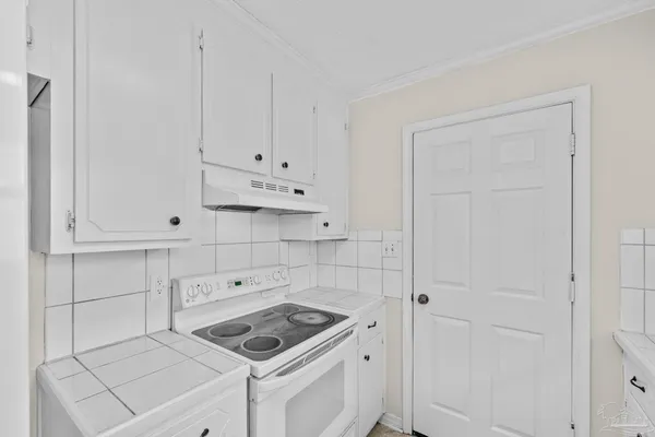 a kitchen with white cabinets and white appliances