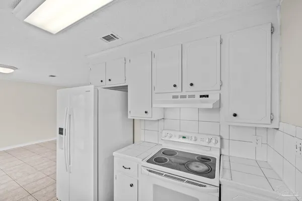 a view of a kitchen with white cabinets