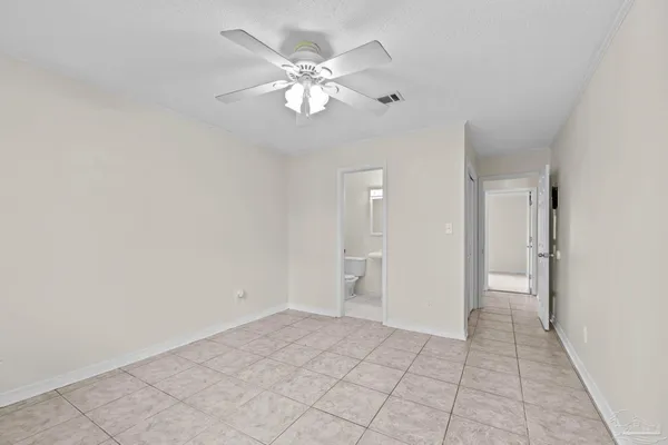 a view of an empty room and chandelier fan