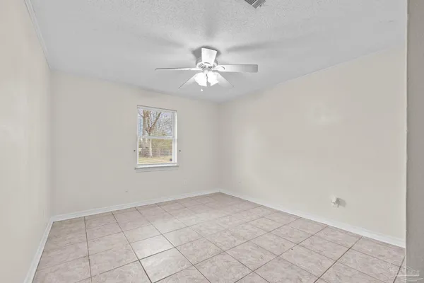 a view of an empty room with a ceiling fan and window