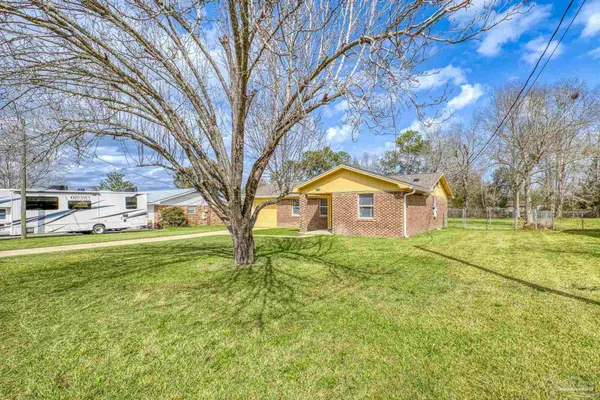 a front view of a house with yard and green space
