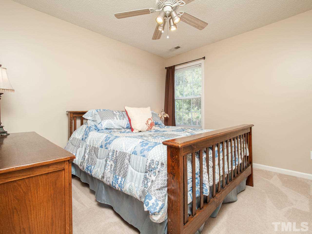 5000 Tommans Trail Raleigh, NC 27616 - Photo 16 of 30 a bedroom with a bed and a chandelier