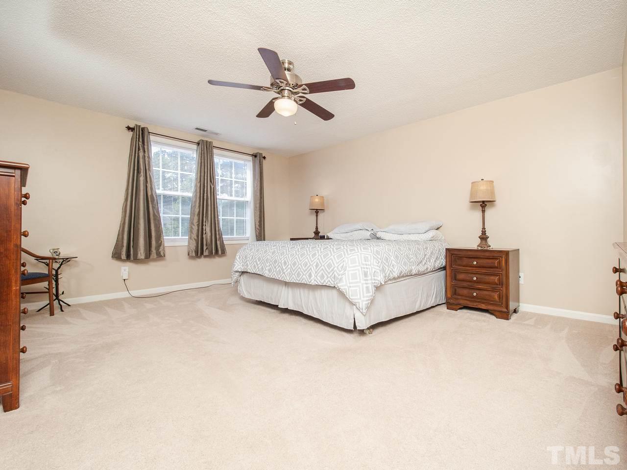 5000 Tommans Trail Raleigh, NC 27616 - Photo 19 of 30 a spacious bedroom with a bed a dresser and a chandelier