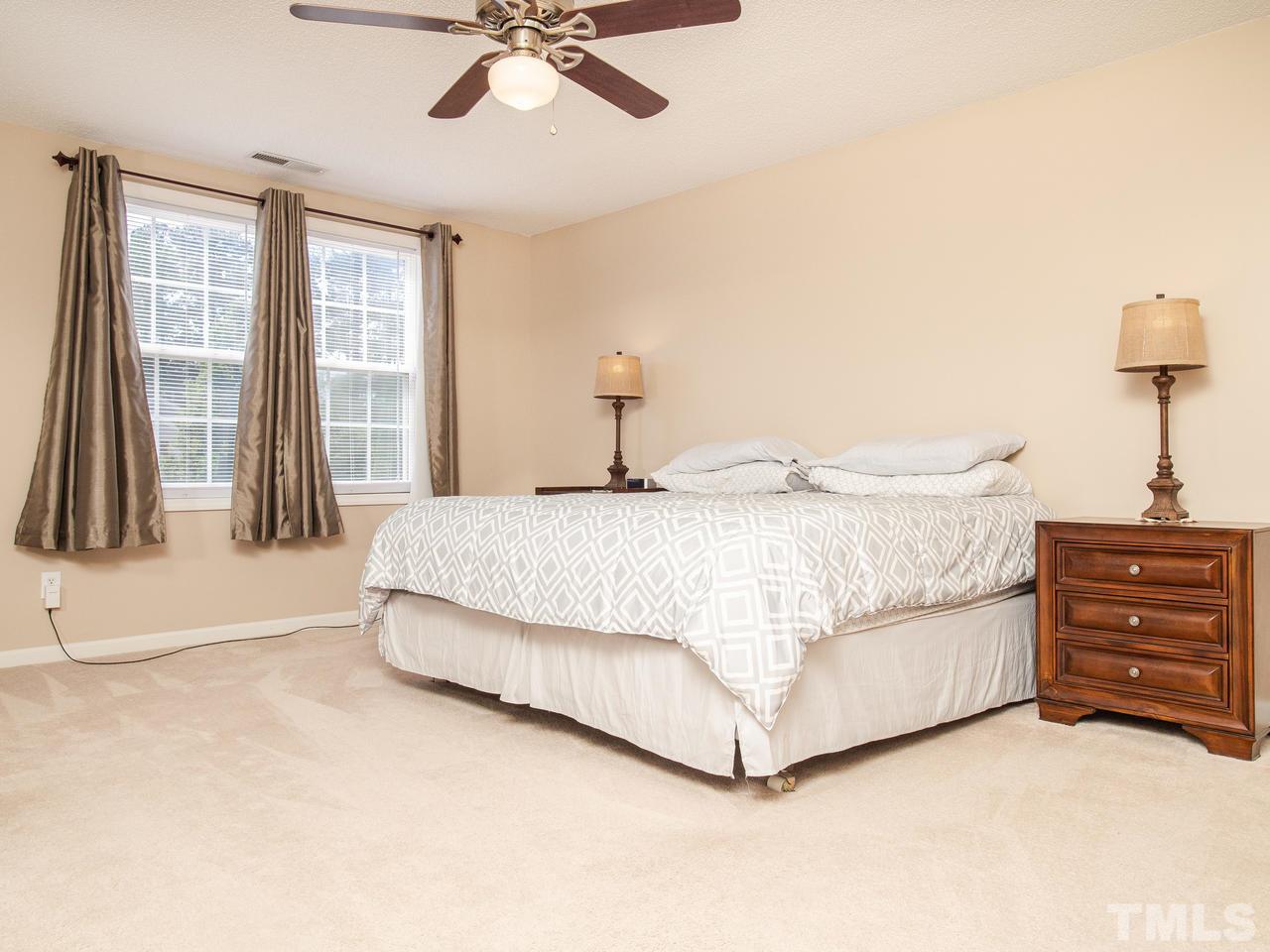 5000 Tommans Trail Raleigh, NC 27616 - Photo 20 of 30 a bedroom with a bed and a chandelier