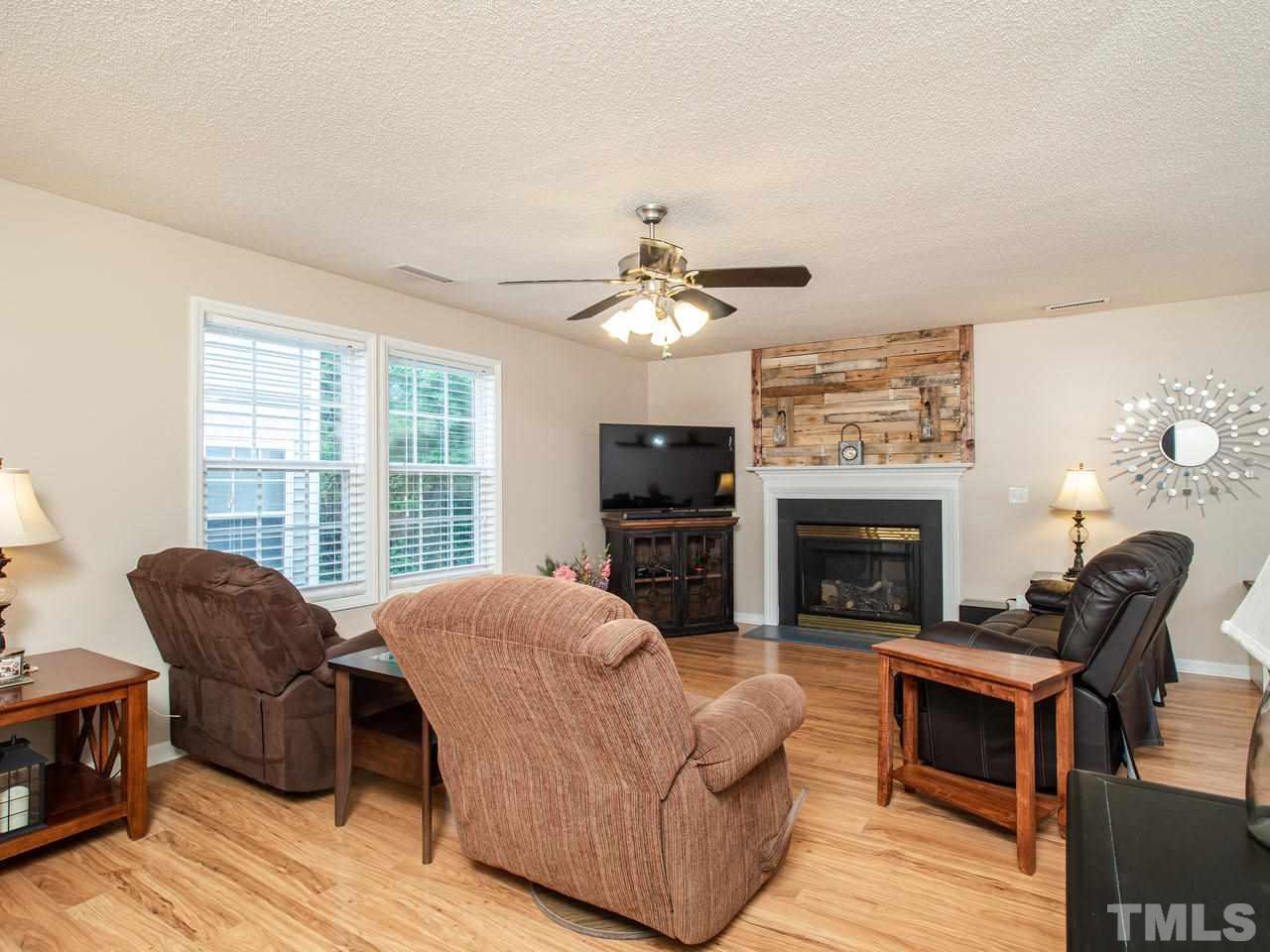5000 Tommans Trail Raleigh, NC 27616 - Photo 6 of 30 a living room with furniture a fireplace and a flat screen tv