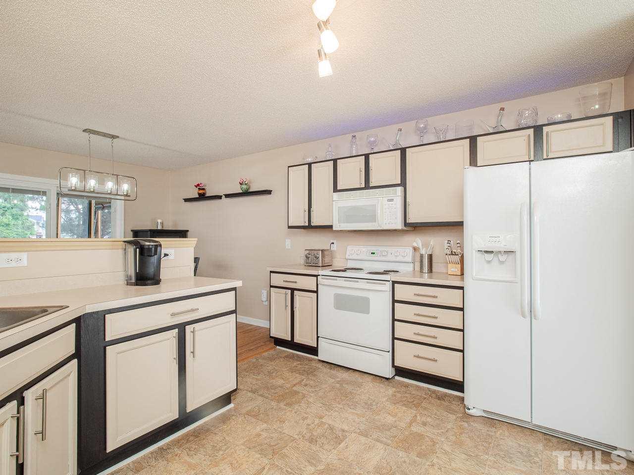 5000 Tommans Trail Raleigh, NC 27616 - Photo 7 of 30 a kitchen with white cabinets and white appliances