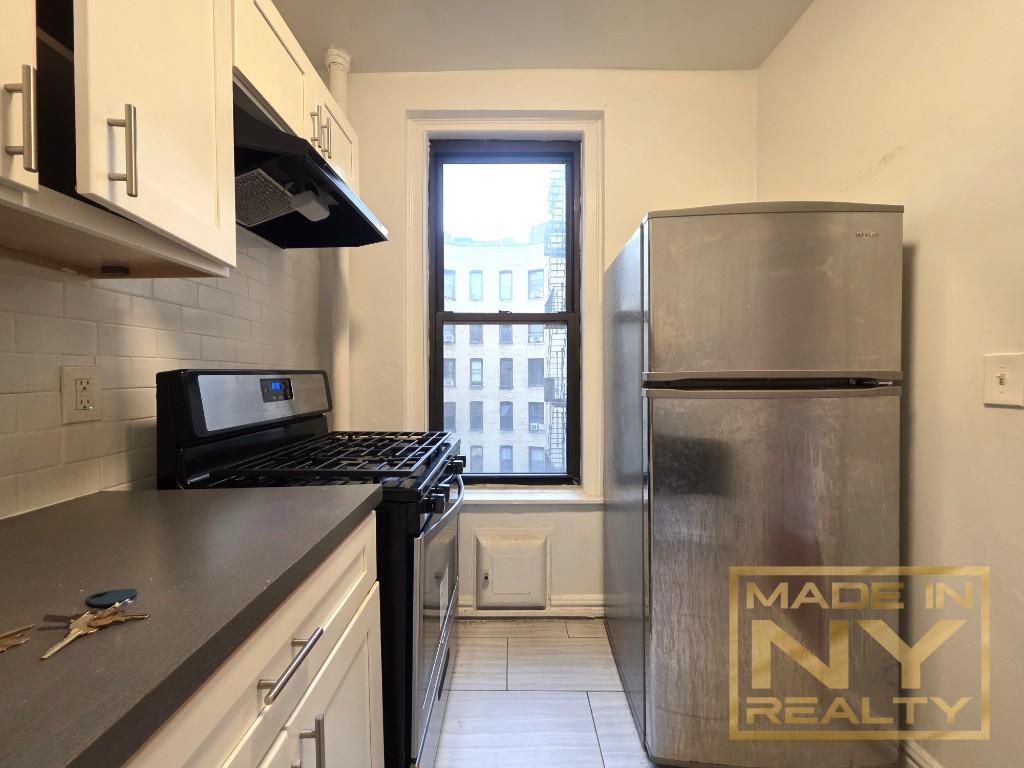 25-21 31st Avenue, Unit A35 Queens, NY 11106 - Photo 2 of 7 a kitchen with a refrigerator and a stove
