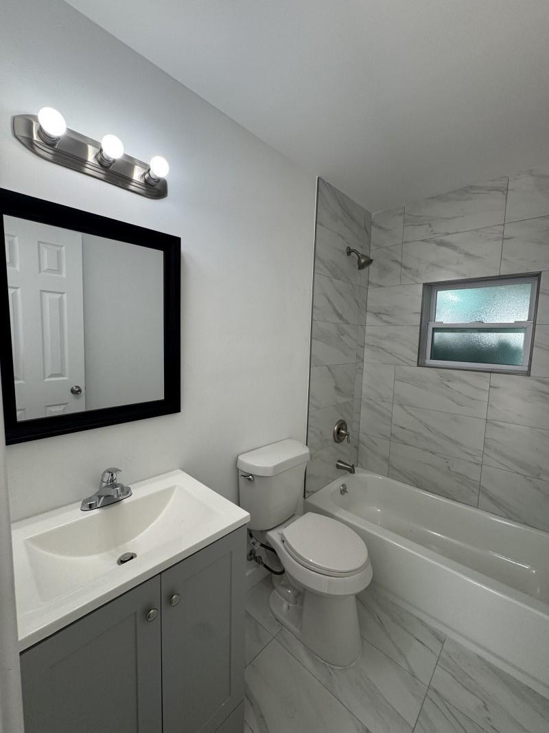 261 Northwest 81st Street, Unit B Miami, FL 33150 - Photo 7 of 12 a bathroom with a toilet sink and mirror