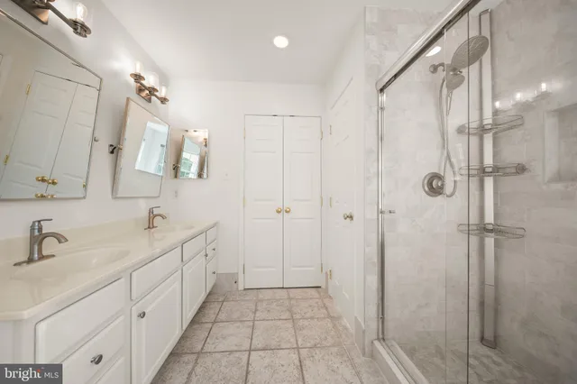 a bathroom with a double vanity sink a mirror and a shower