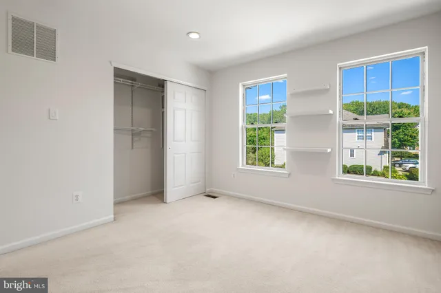 an empty room with windows and closet