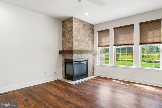 a view of an empty room with a kitchen and a window