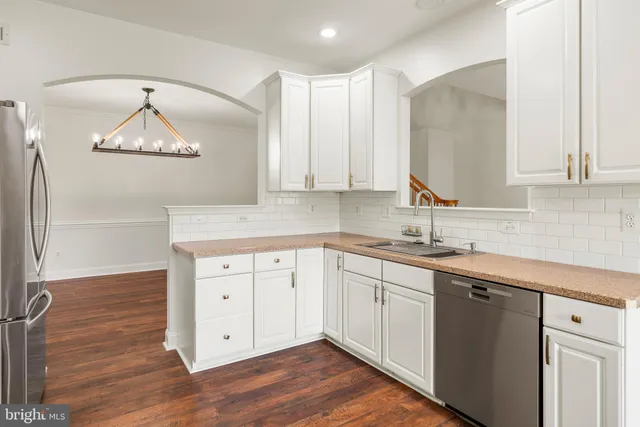 a kitchen with a sink cabinets and wooden floor