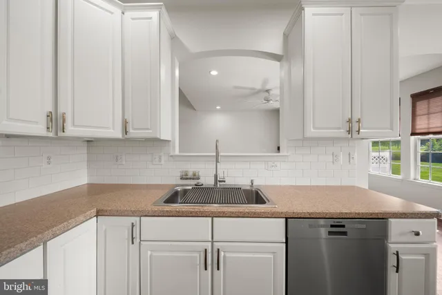 a kitchen with stainless steel appliances granite countertop a sink and a white cabinets