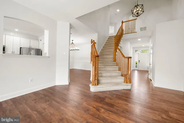 a view of a hallway with wooden floor and entryway